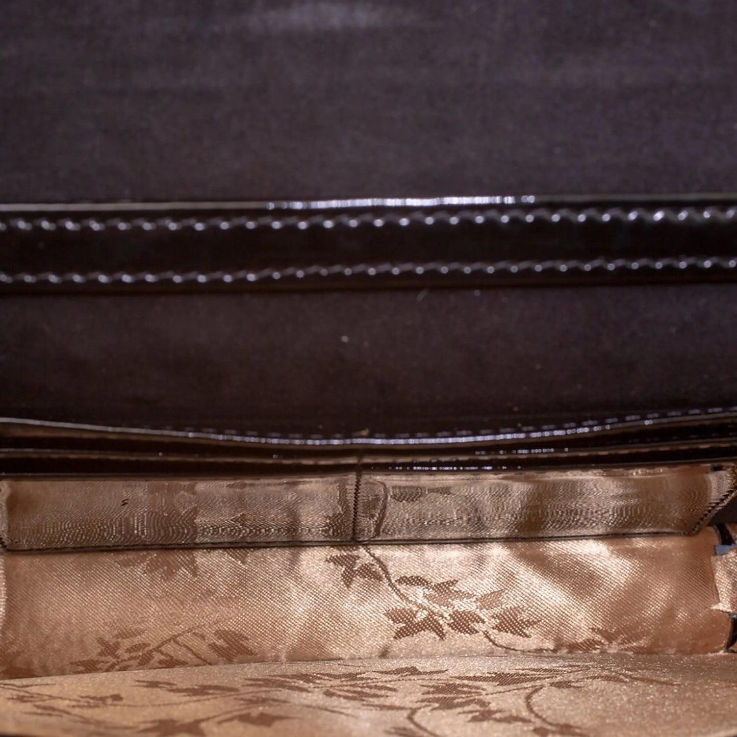 Diamond quilted leather crossbody clutch with a floral patterned interior