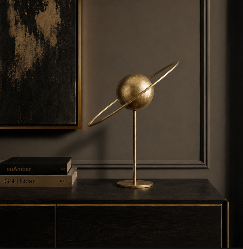 Gold iron solar system tabletop sculpture displayed on a dark wood console in an elegant contemporary interior.