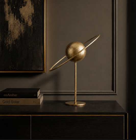 Gold iron solar system tabletop sculpture displayed on a dark wood console in an elegant contemporary interior.