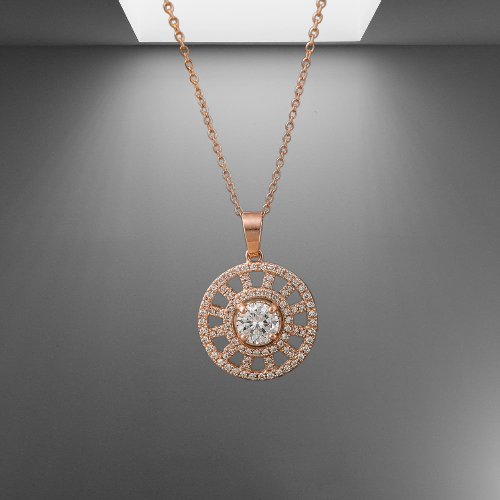 Rose gold pendant necklace with sunburst wheel design and white CZ stones, on gray studio background